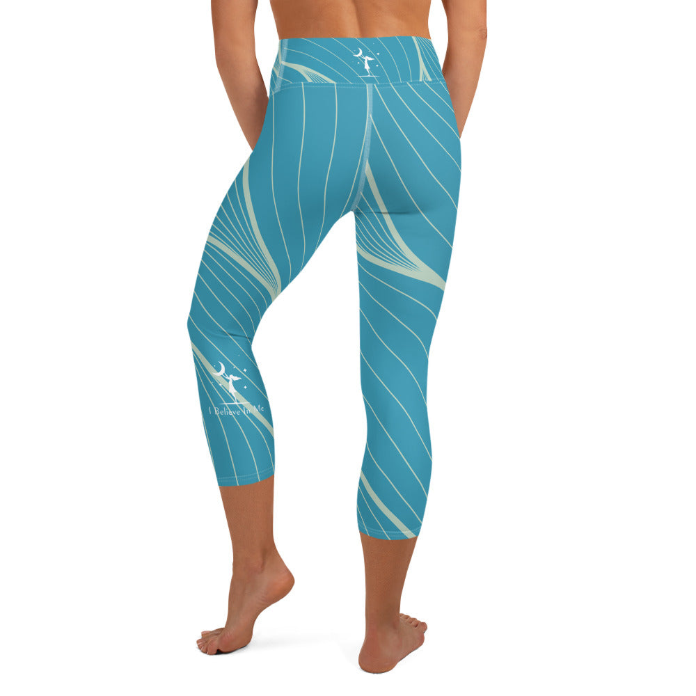 view of a barefoot woman wearing rear teal with tan stripes capri length yoga pants