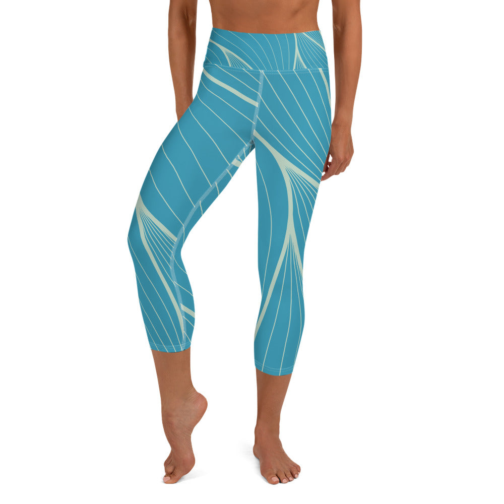 front view of a barefoot woman wearing teal with tan stripes capri length yoga pants