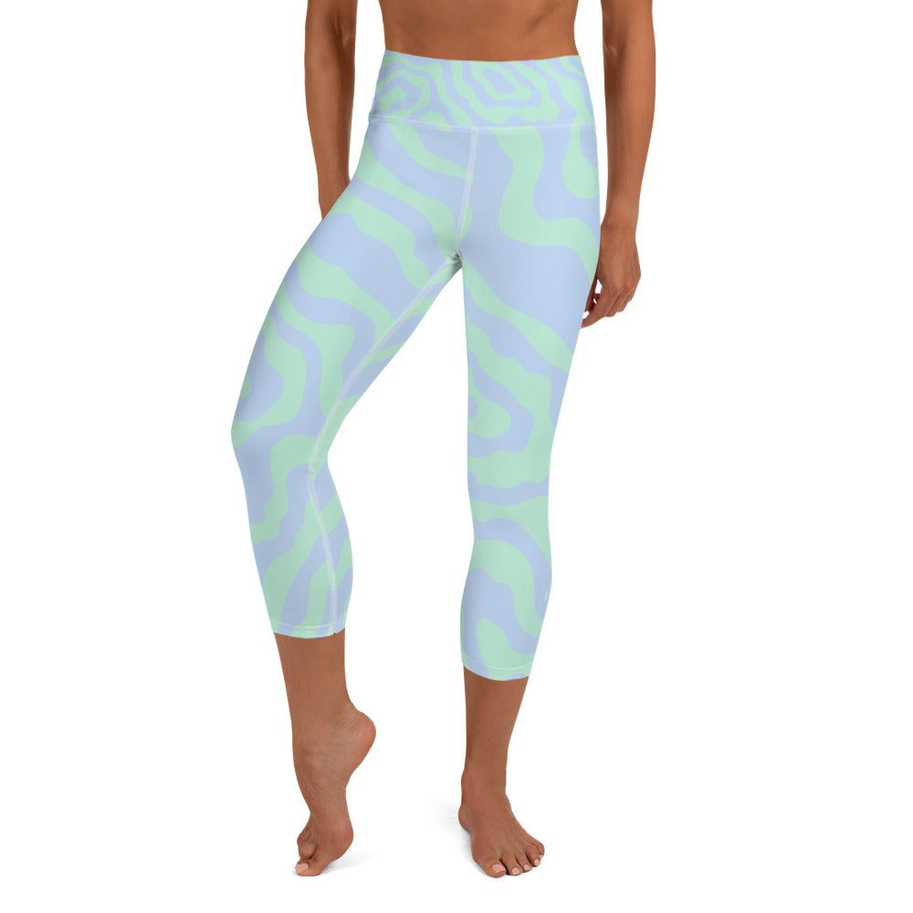 front view of a barefoot woman wearing light purple and mint colored capri length yoga pants