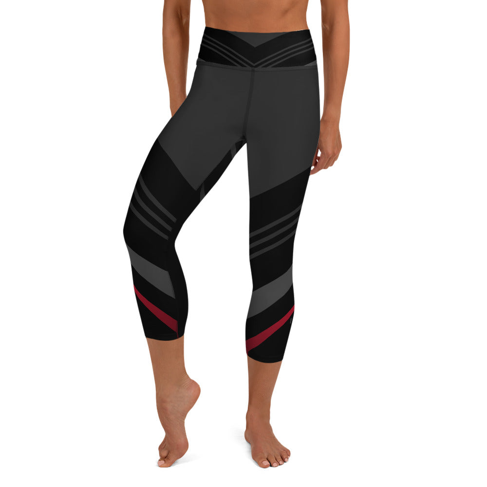 front view of a barefoot woman wearing black and grey capri length yoga pants