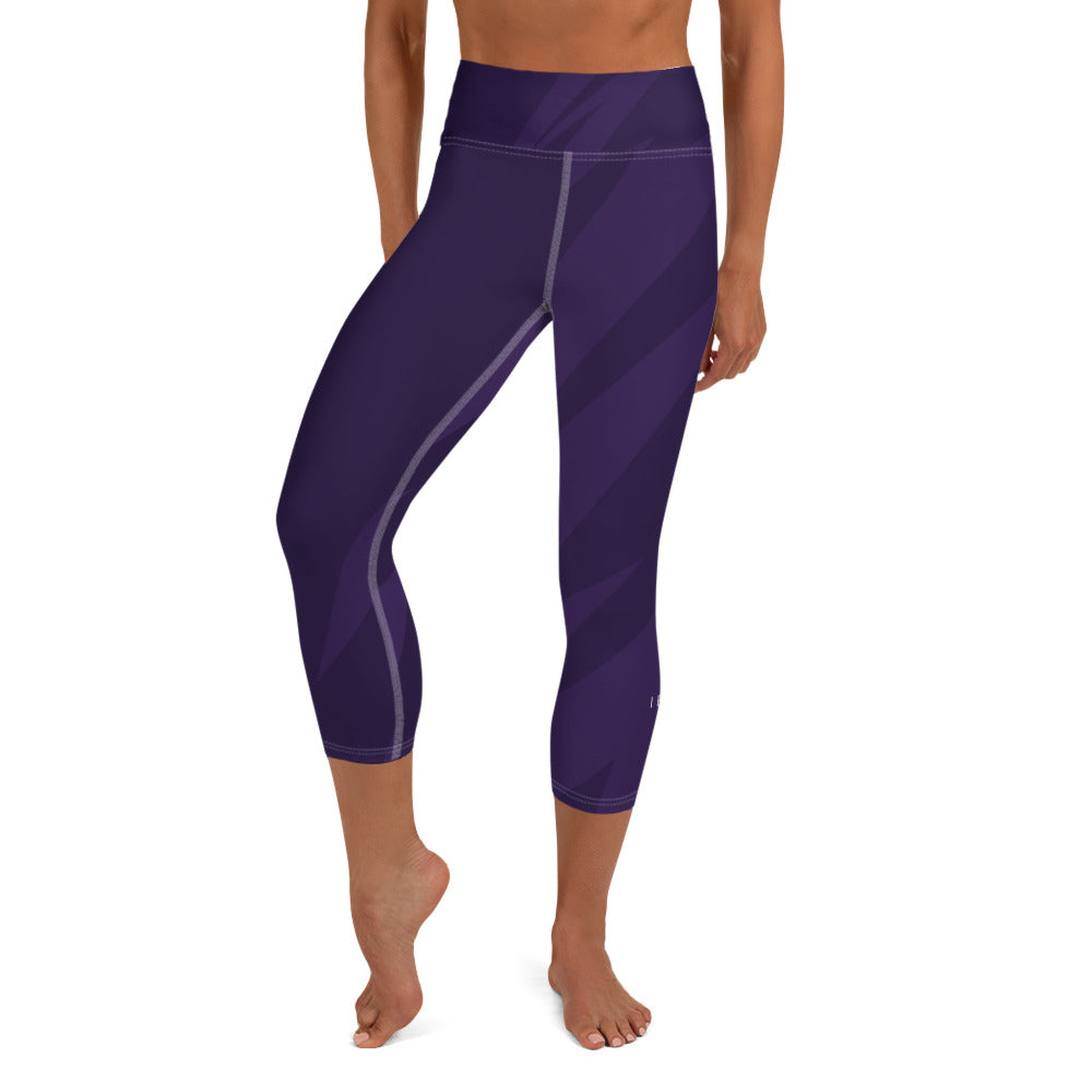 front view of a barefoot woman wearing purple capri length yoga pants 